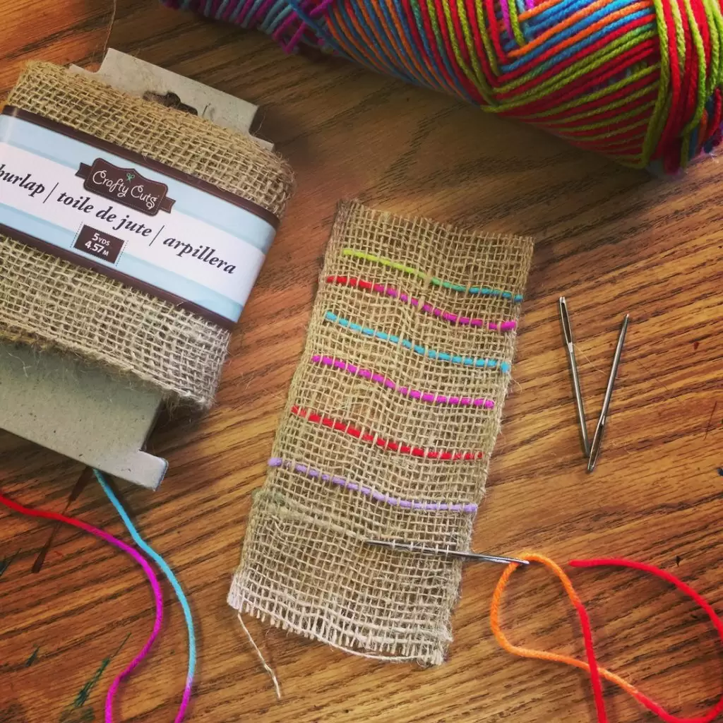 A beginner weaving project made with burlap ribbon and yarn.