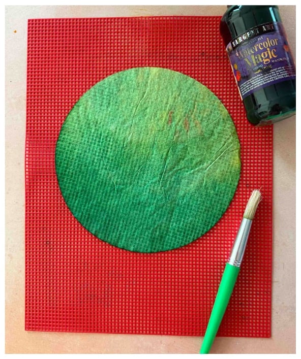 Painting coffee filters green to make trees for a fall tree art project.